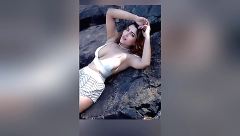 A hot redhead on a beach is riding a cock on a beach