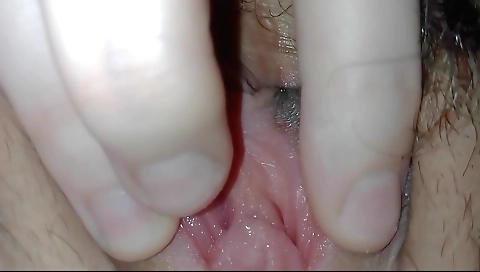 Hairy brunette girl is on her back and she is fingering her pussy