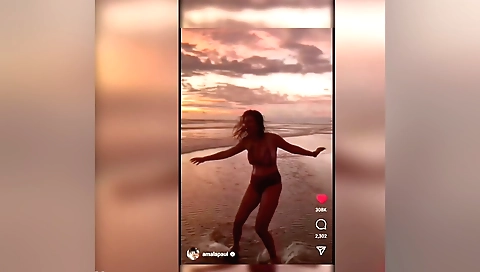 Beautiful brunette in black dress takes off clothes