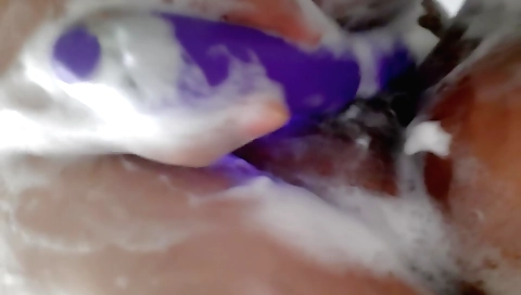 Charming solo female is playing with a toy in the shower